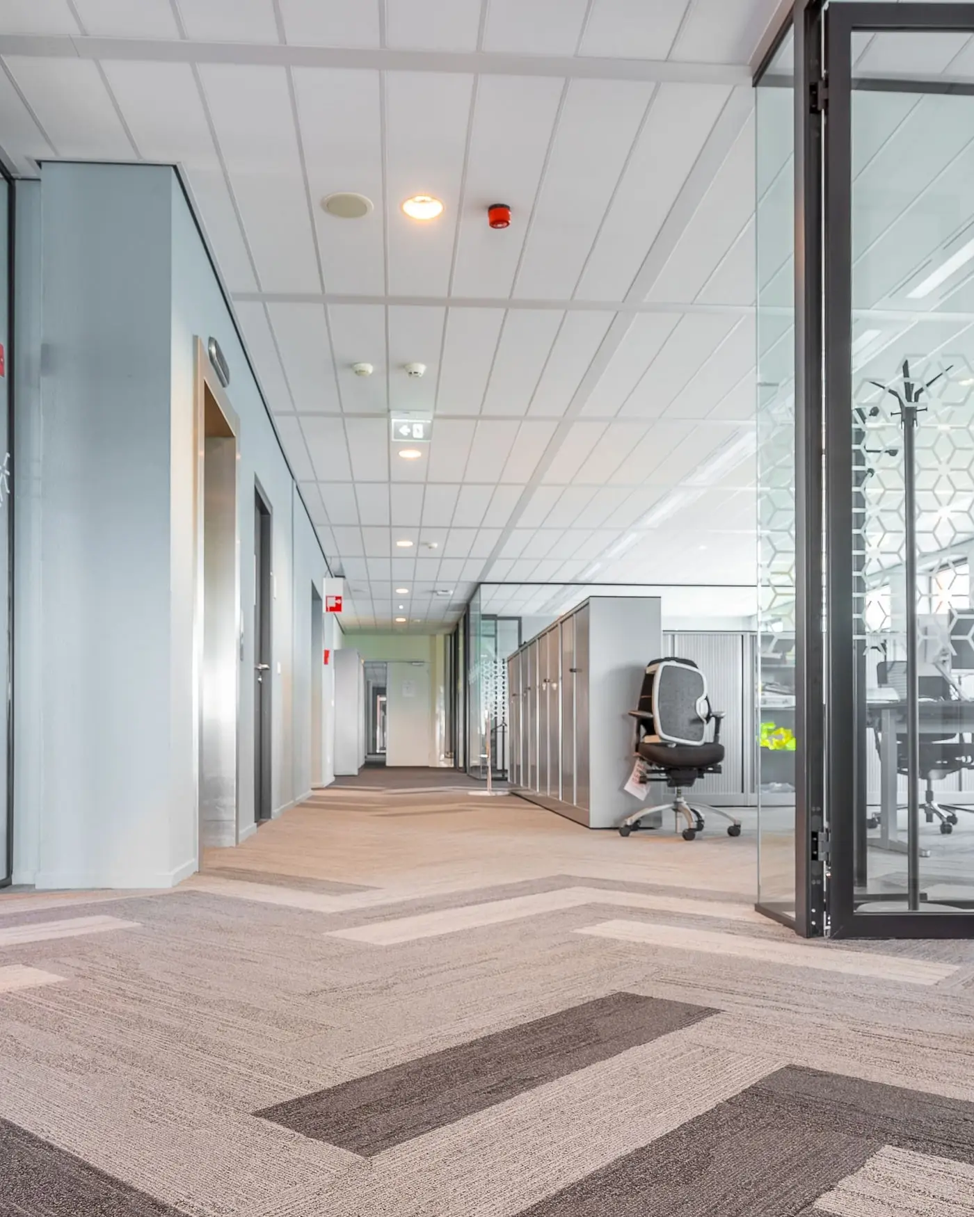 Clean modern commercial office corridor with glass partitions and polished flooring