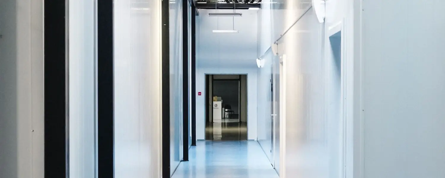 Clean corridor inside an industrial building with exposed steelwork and a spotless floor