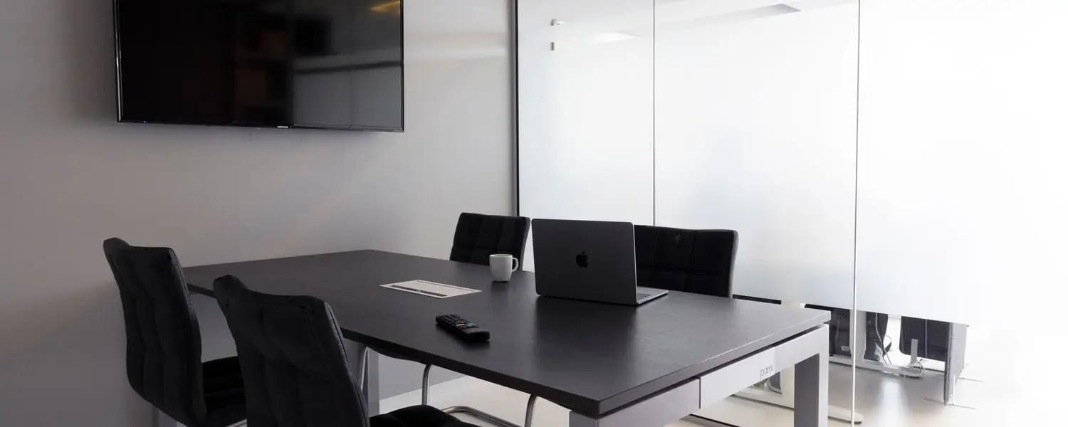 Meeting room in a modern office with a clean table, chairs and glass partition wall